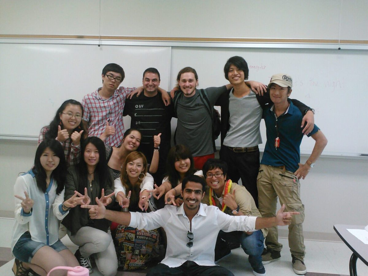 international students in a classroom, smiling in a group photo